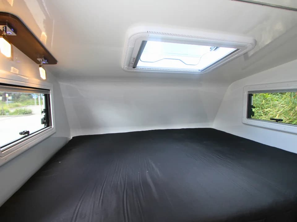 2026 Made by Smidge Long Weekend — over-cab bed in raised/closed position showing clearance for travel