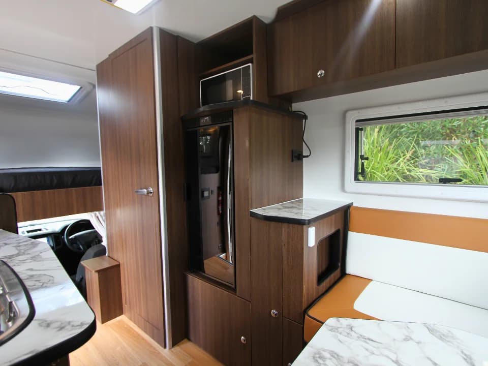 2026 Made by Smidge Long Weekend — interior lounge area with convertible seating and dinette layout