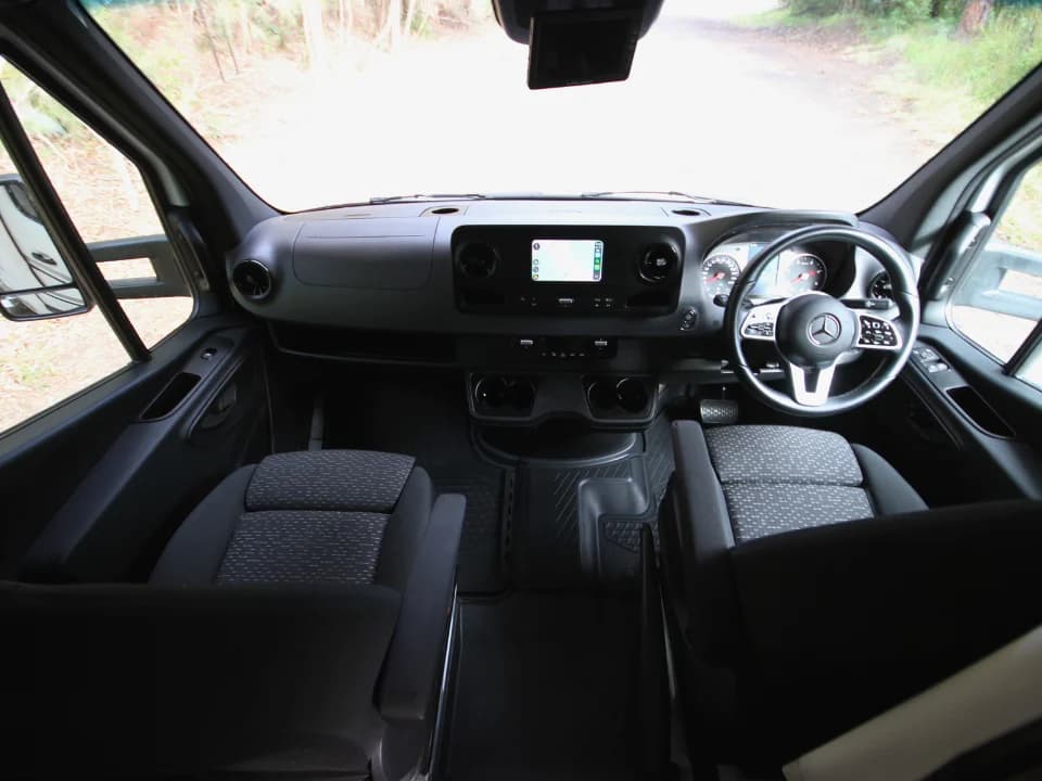 Mercedes-Benz Sprinter cab interior — driver and passenger seats with touchscreen infotainment