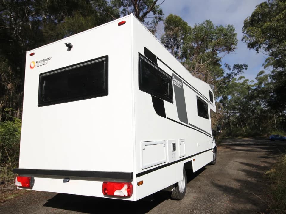 Saxby F-2 rear driver-quarter exterior — Suncamper branding and panoramic rear window