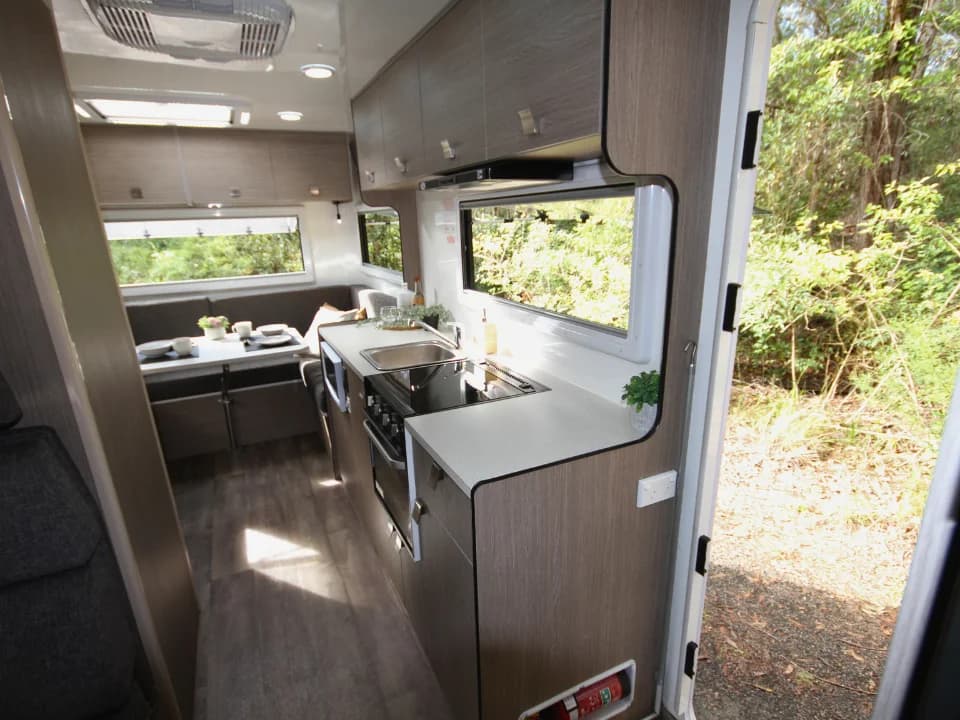 Saxby F-2 interior — view from entry door showing kitchen bench, sink and dinette seating beyond