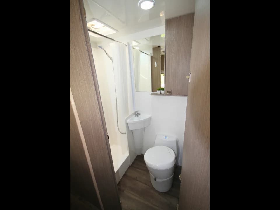 Saxby F-2 demo interior — separate bathroom with shower recess, Thetford cassette toilet and vanity mirror