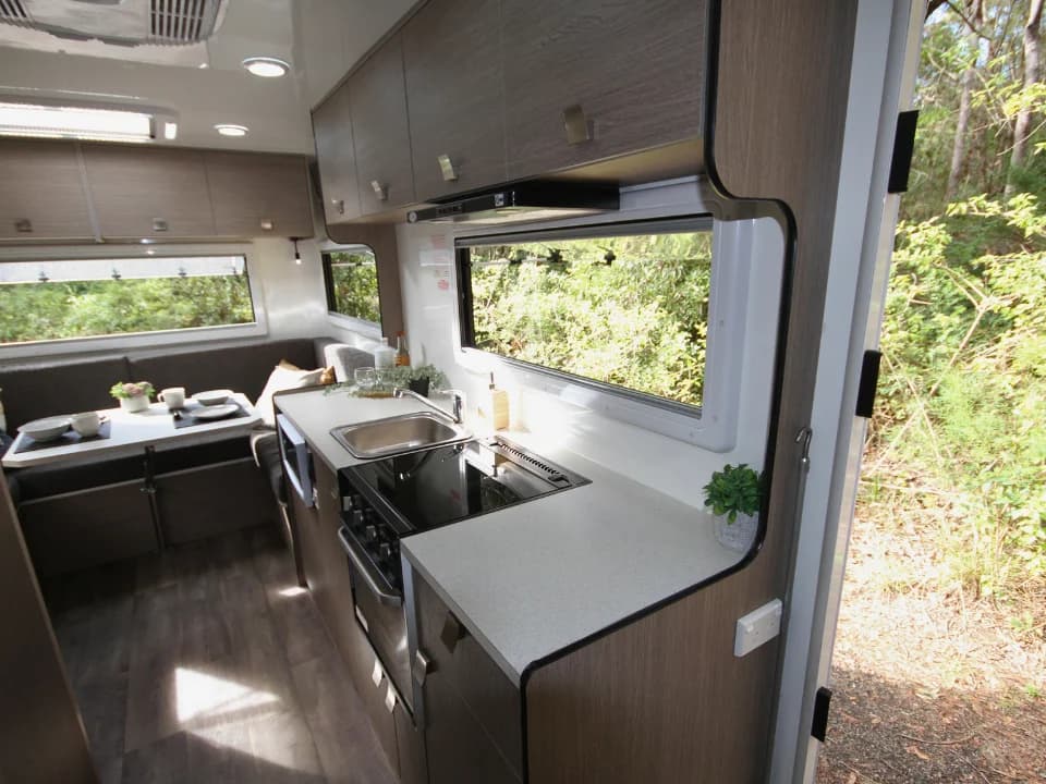 Saxby F-2 demo interior — view from entry door showing kitchen bench and dinette seating beyond