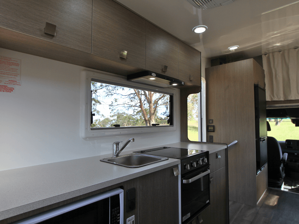 2024 Saxby F-2 demo interior — kitchen with 174L compressor fridge and grill/oven combo