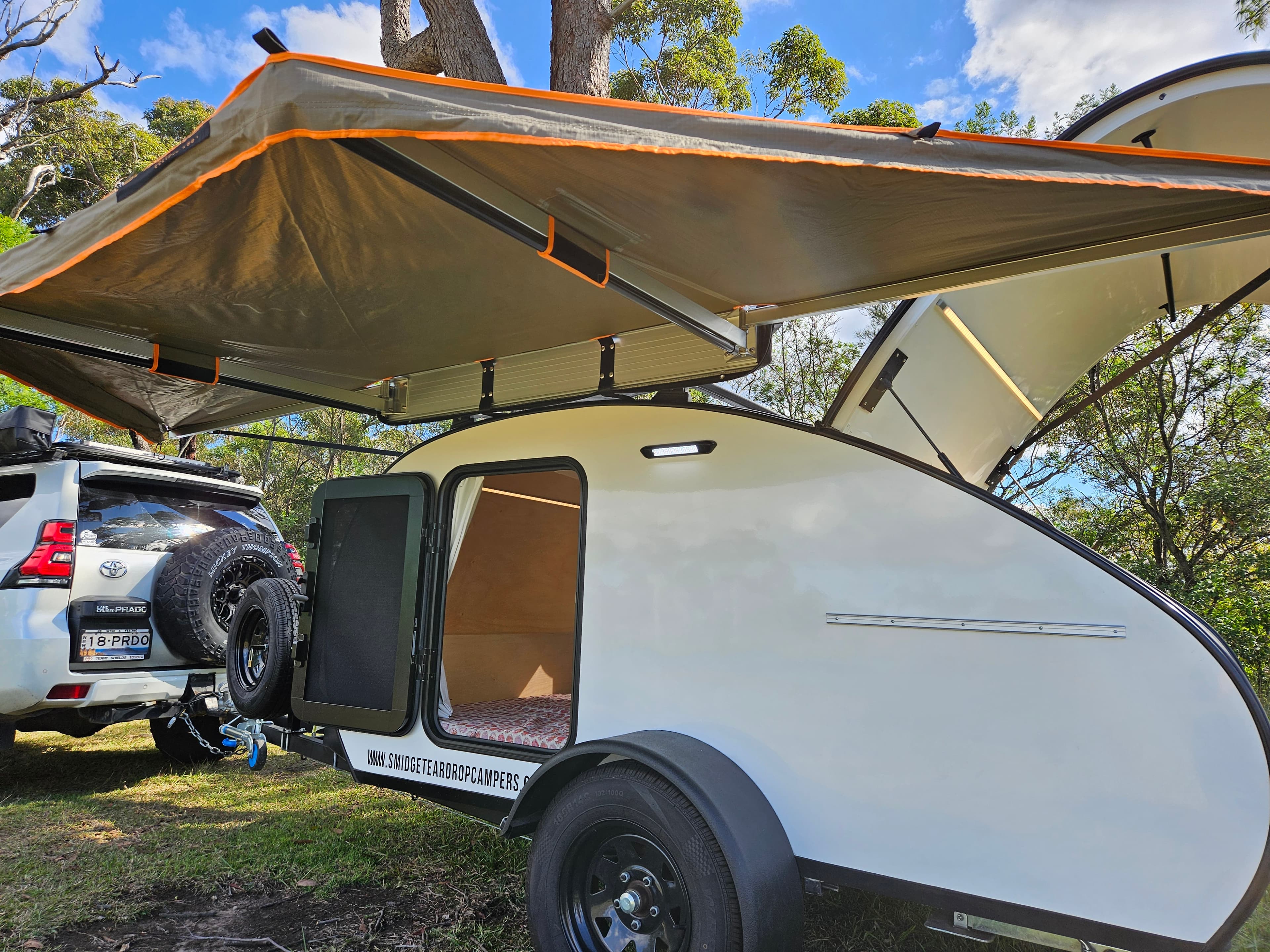 2024 Smidge Breeze — 180° awning deployed providing full-length shade coverage