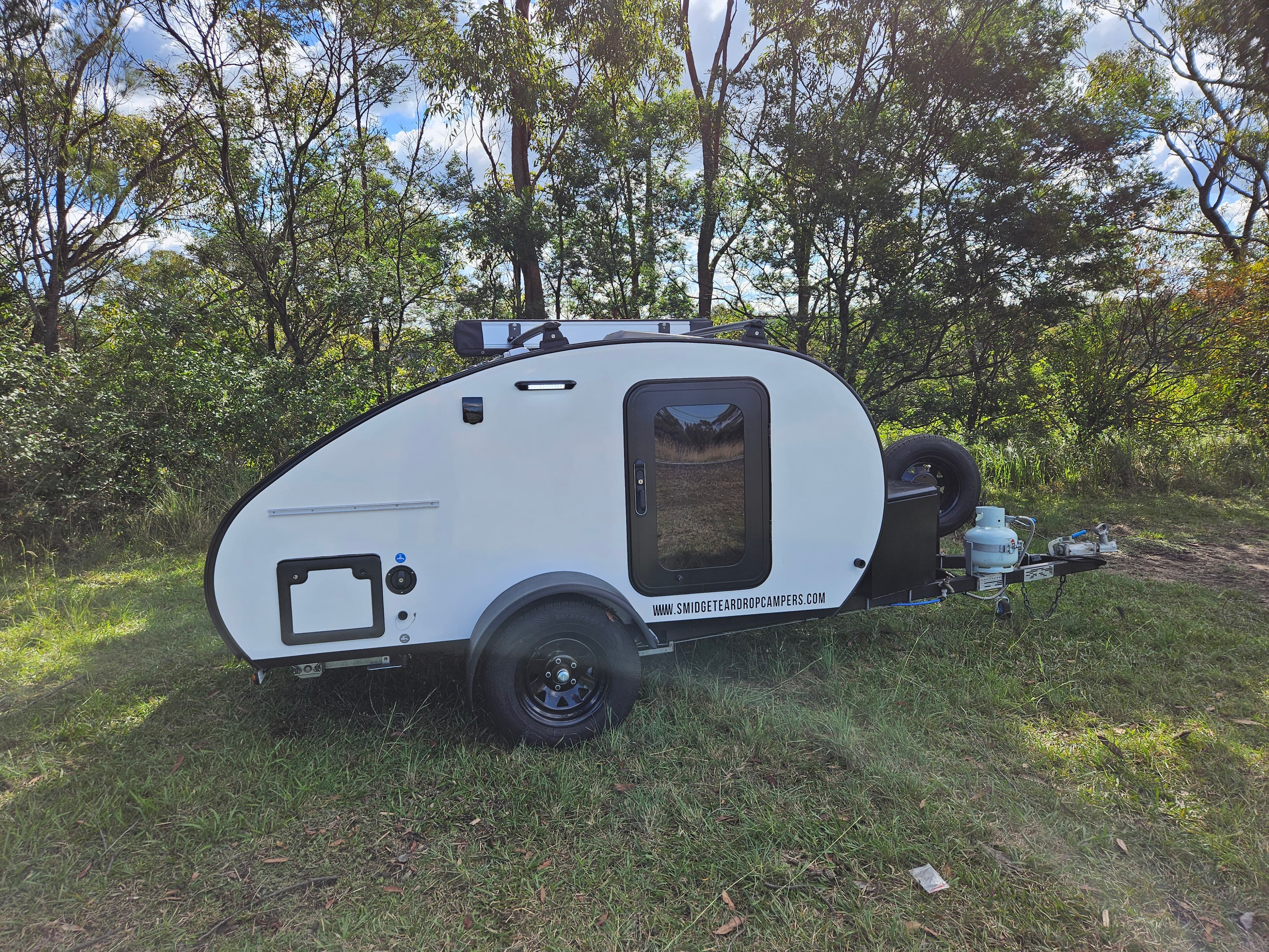 2024 Smidge Breeze teardrop trailer — driver side exterior showing roof racks and 100W solar panel