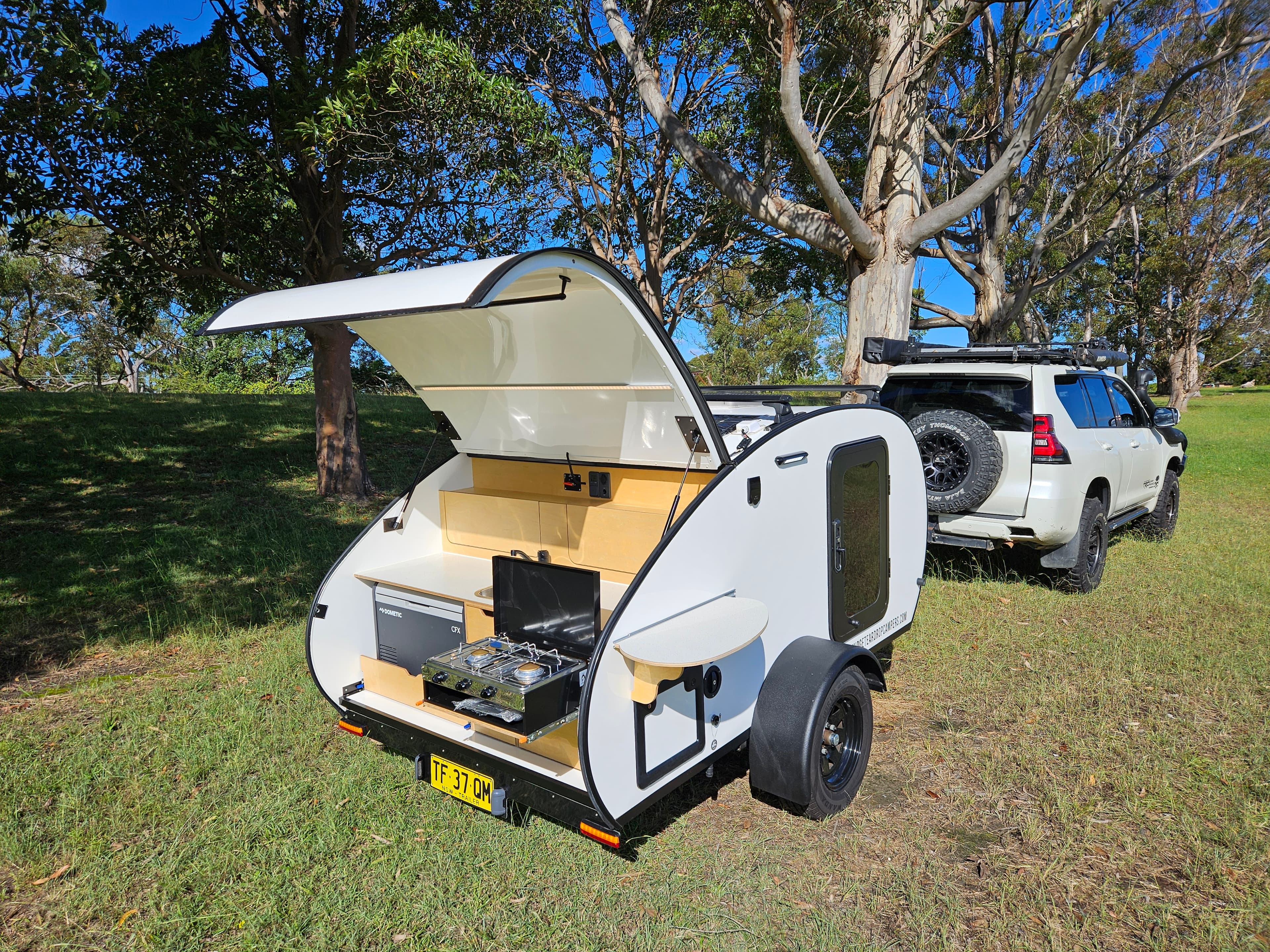 2024 Smidge Breeze — rear galley open showing two-burner gas stove and kitchen layout