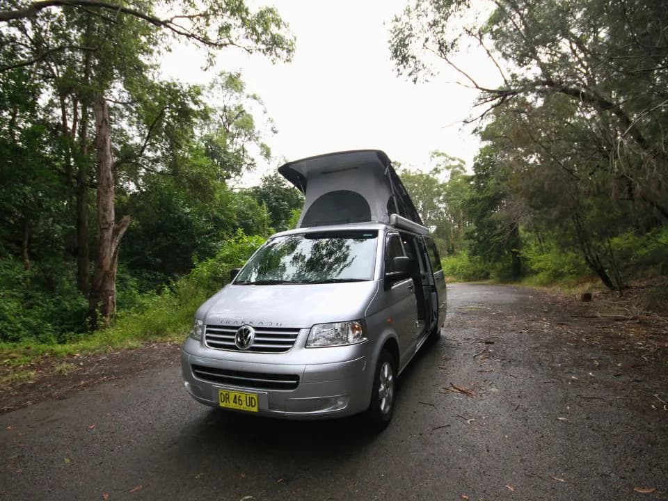 2007 Trakka Trakkadu T5 campervan — front three-quarter exterior with the aerodynamic pop-top roof raised and sliding door open