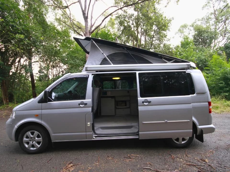 2007 Trakka Trakkadu T5 campervan — driver's side with pop-top raised and sliding door open showing the interior kitchen