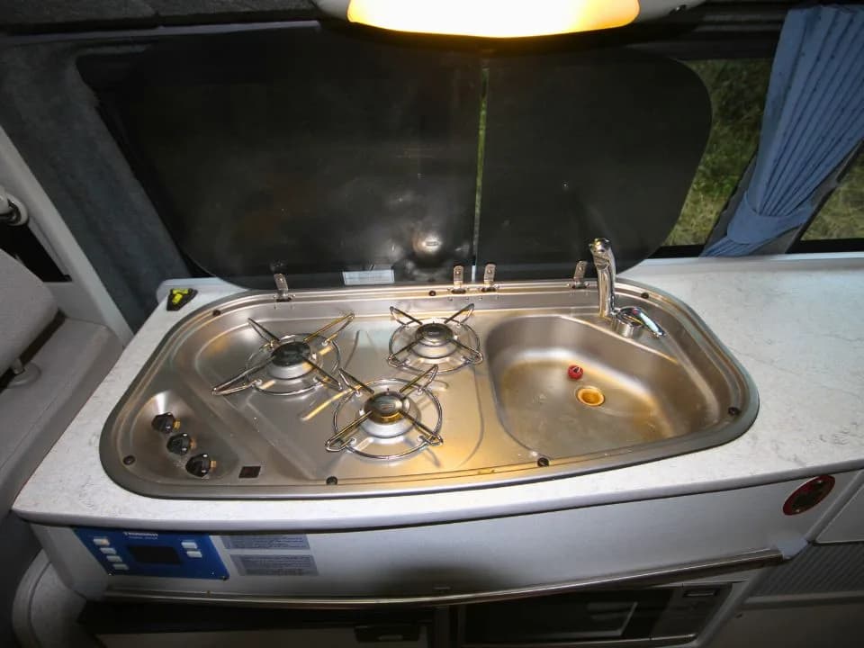 2007 Trakka Trakkadu T5 campervan — stainless steel sink and cooktop with the glass lid raised