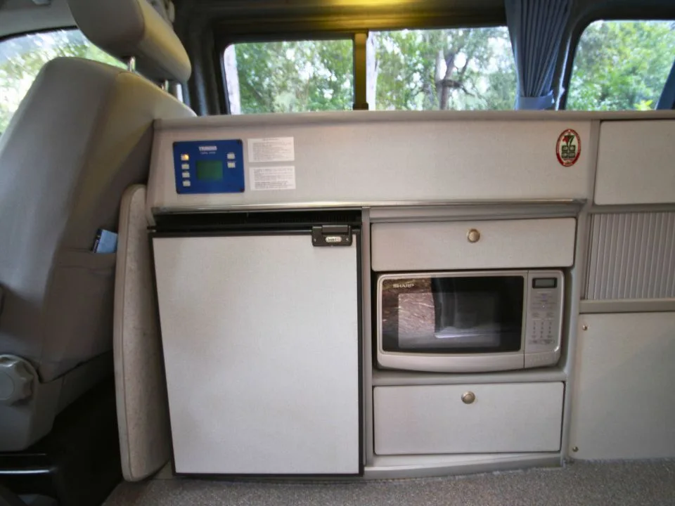 2007 Trakka Trakkadu T5 campervan — interior cabinetry with roller-shutter doors and microwave