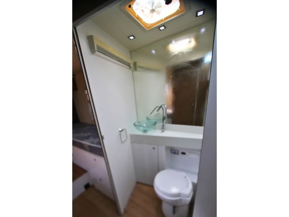 2011 Suncamper Sydney motorhome — interior bathroom with toilet, glass bowl vanity basin and mirror