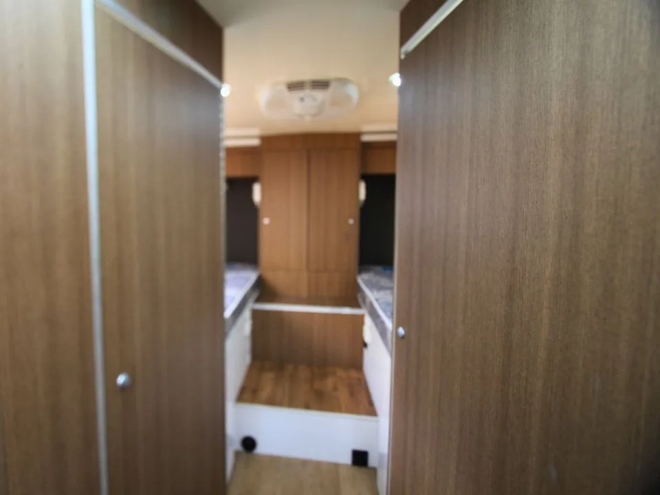 2011 Suncamper Sydney motorhome — interior twin single beds viewed through wardrobe doorway