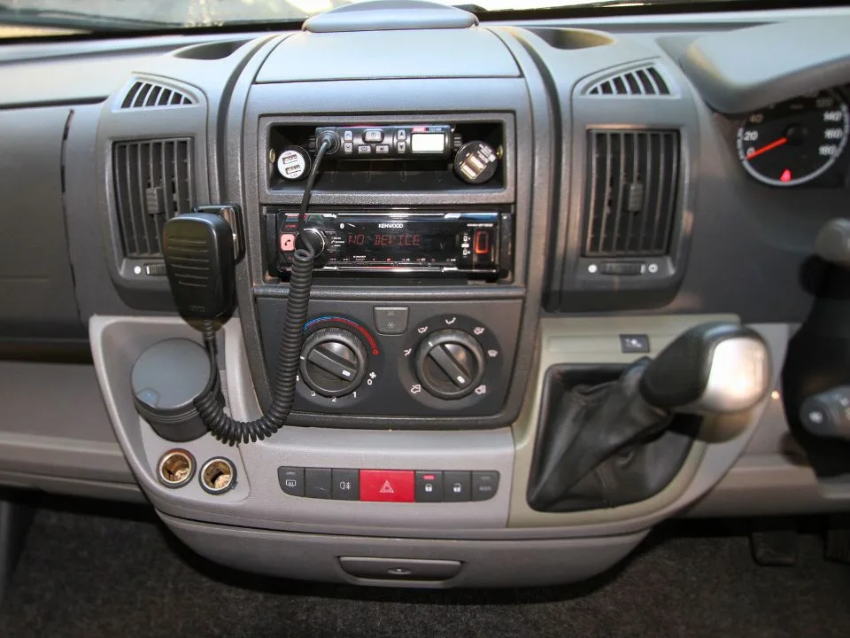 2011 Suncamper Sydney motorhome — cab dashboard with Kenwood head unit and UHF CB radio