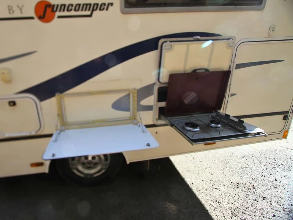 2011 Suncamper Sydney motorhome — exterior outdoor kitchen with 2-burner gas cooktop and fold-down table