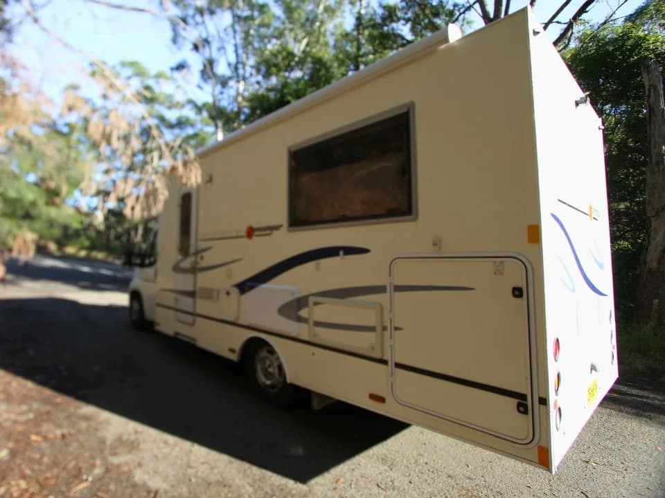 2011 Suncamper Sydney motorhome — driver's side exterior showing rear storage compartment