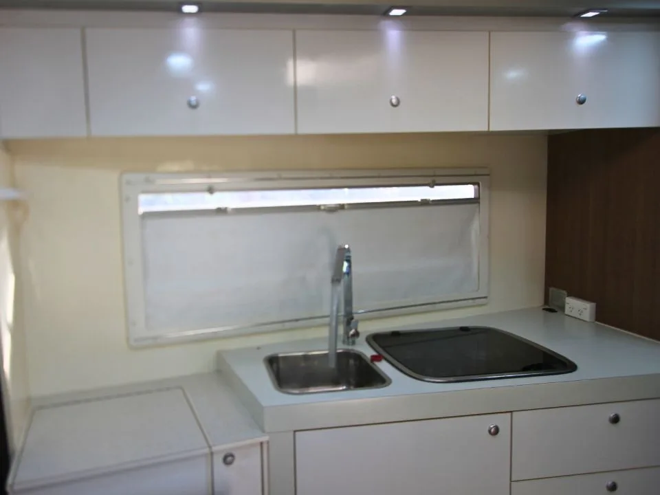 2011 Suncamper Sydney motorhome — interior kitchen with stainless sink, gas cooktop and overhead cupboards
