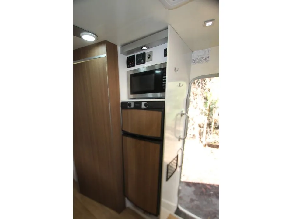 2011 Suncamper Sydney motorhome — interior kitchen with microwave and Dometic fridge