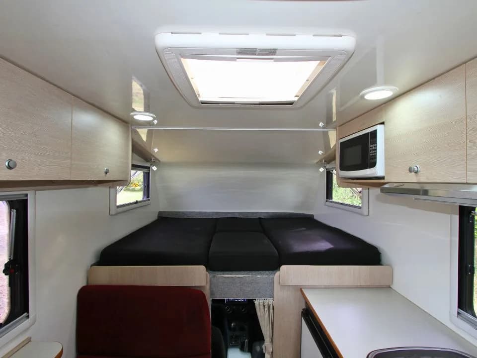 2015 Suncamper Sherwood 4x4 Twin motorhome — interior over-cab twin beds, overhead view