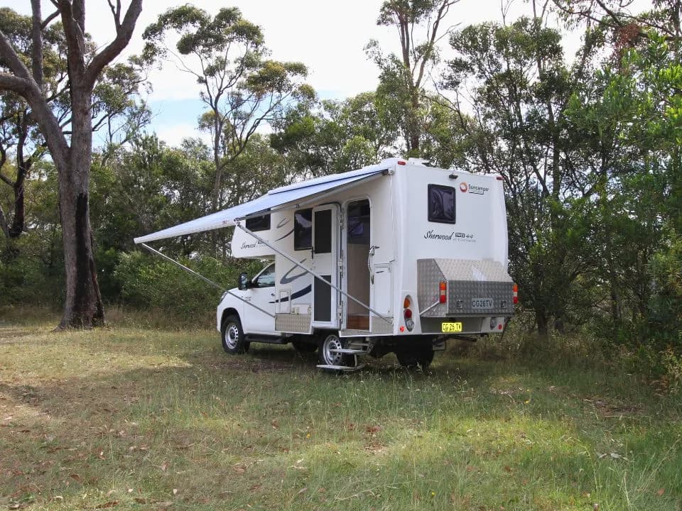 2015 Suncamper Sherwood 4x4 Twin motorhome — rear three-quarter exterior with awning extended