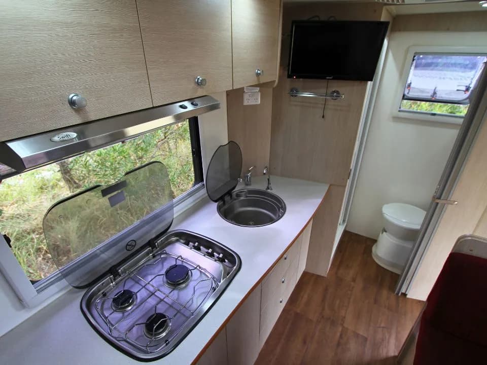 2015 Suncamper Sherwood 4x4 Twin motorhome — interior kitchen 3-burner cooktop and sink