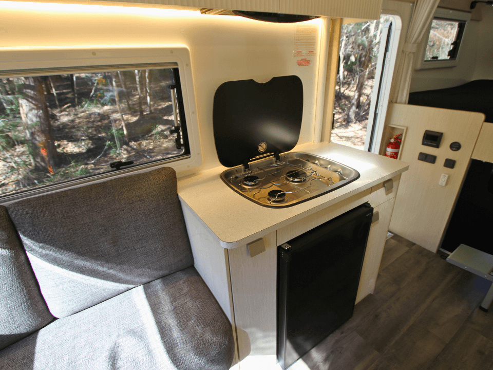 2024 Suncamper Sherwood E-2 interior — kitchen with gas cooktop and fridge